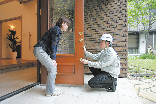 写真：玄関ドアを点検するスタッフ　住友不動産