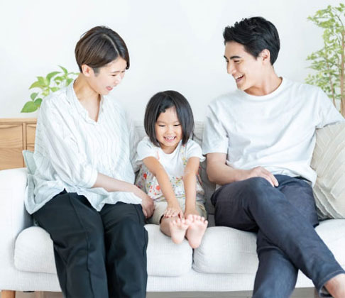 写真:ソファの上で団欒する家族 桧家住宅