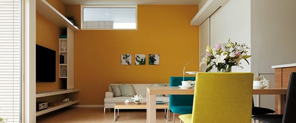 写真：オレンジ色の壁がアクセントのシンプルなリビング　ミサワホーム