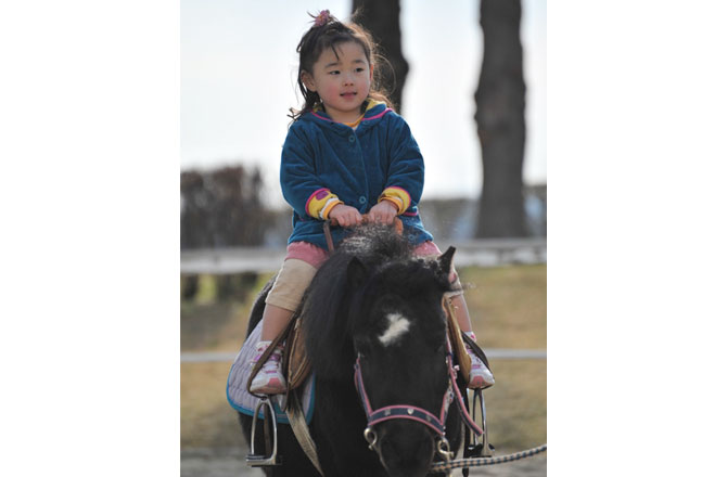 写真:ポニーに乗る子供