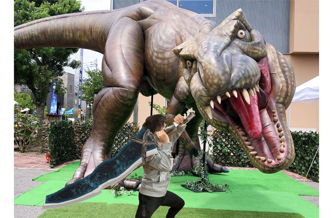 写真：武器を持って巨大恐竜に立ち向かう男の子