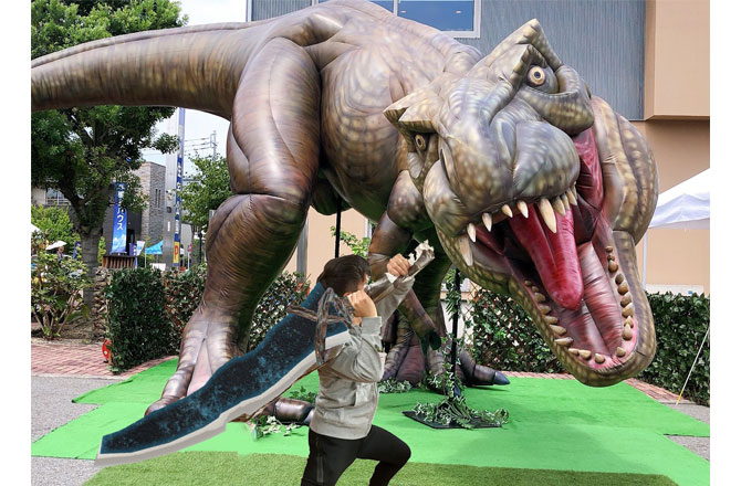 写真:武器を持って巨大恐竜に立ち向かう男の子