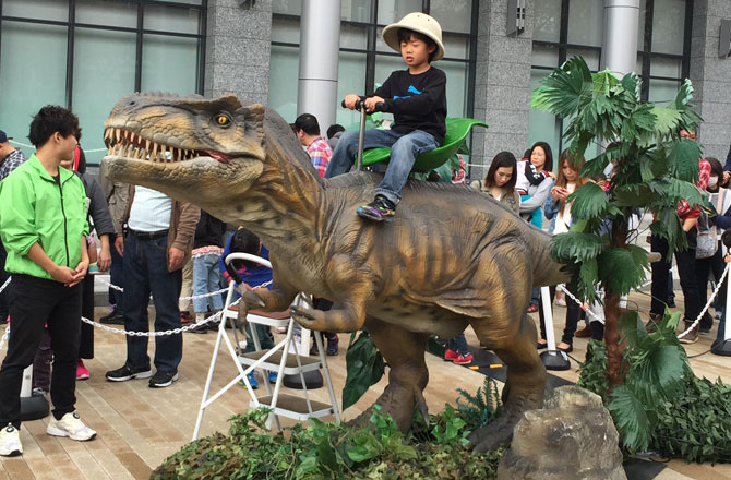 写真：ティラノサウルスに乗る男の子