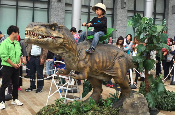 写真:ティラノサウルスに乗る男の子