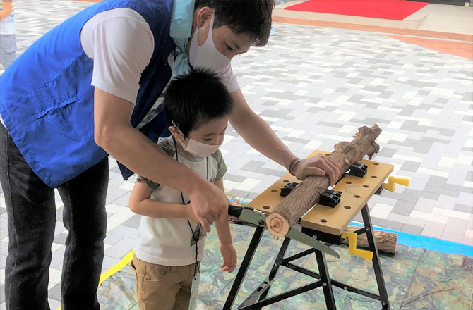 写真:丸太を切る子ども