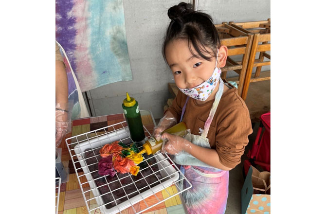 写真:ダイダイ染めをする女の子