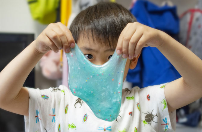 写真:ラメ入りのスライムを触る男の子