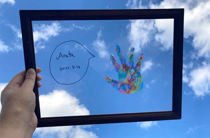 写真:空にかざす手形アート