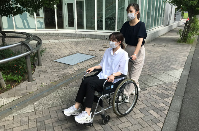 写真:車いすを押す女性