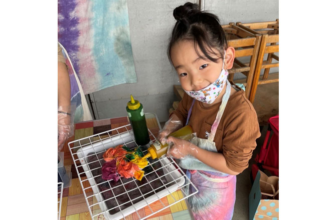 写真:タイダイ染めのTシャツを作る女の子