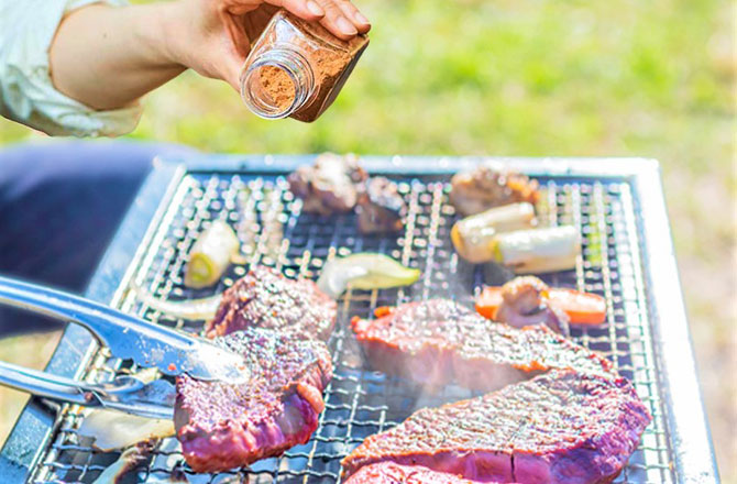写真:お肉にスパイスを振りかける写真